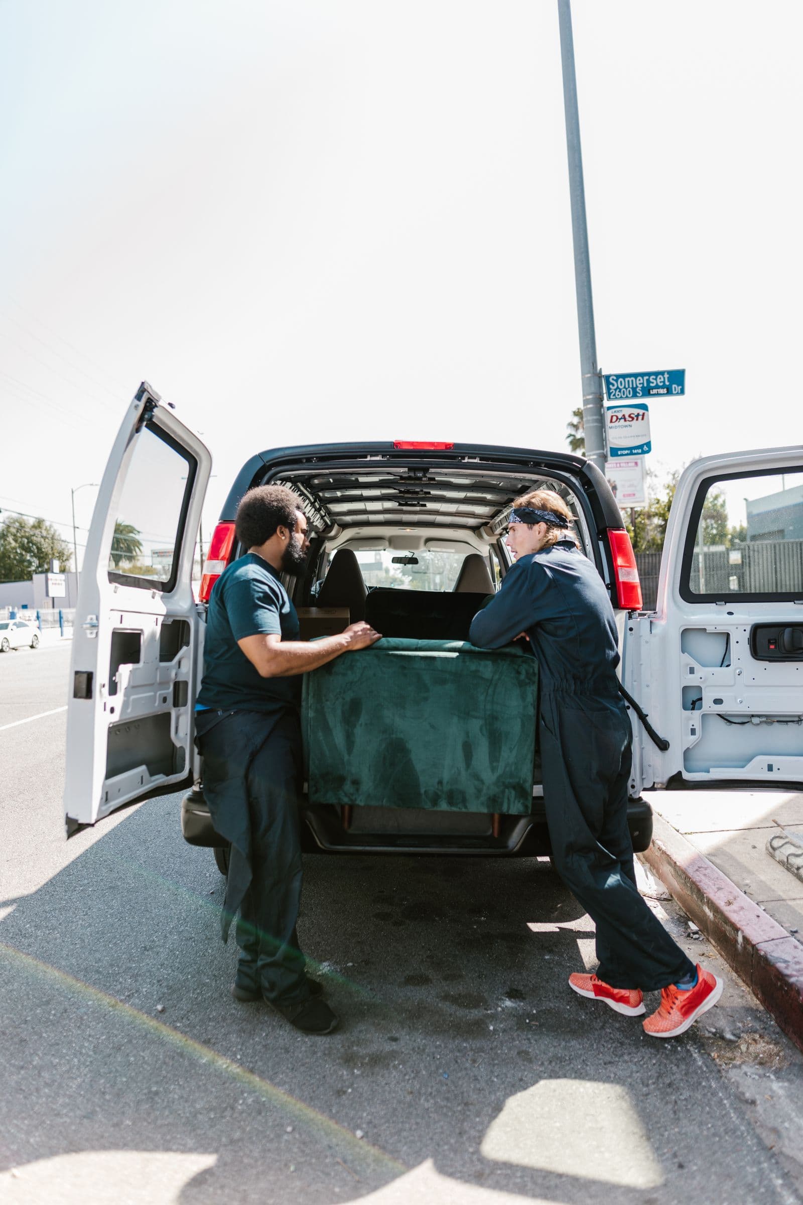 Two Vantage movers carefully loading furniture into a moving van